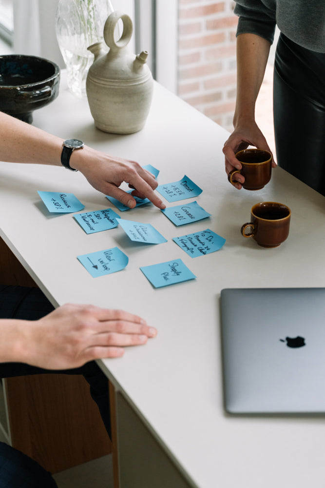 De WBshopmaker wijzend naar blauwe post-its voor optimalisatie