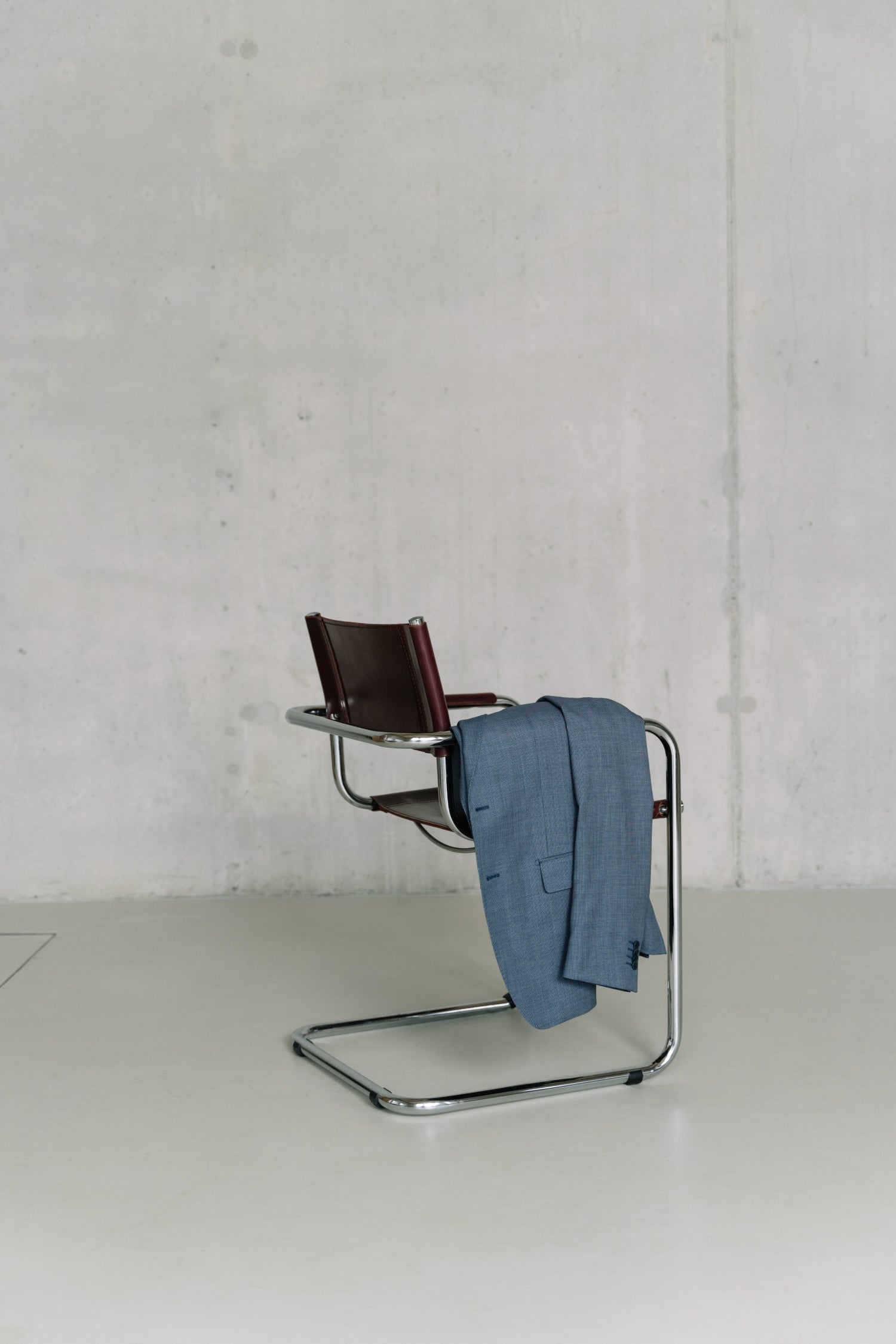 Blauw colbert hangend over een bureaustoel - De WBshopmaker